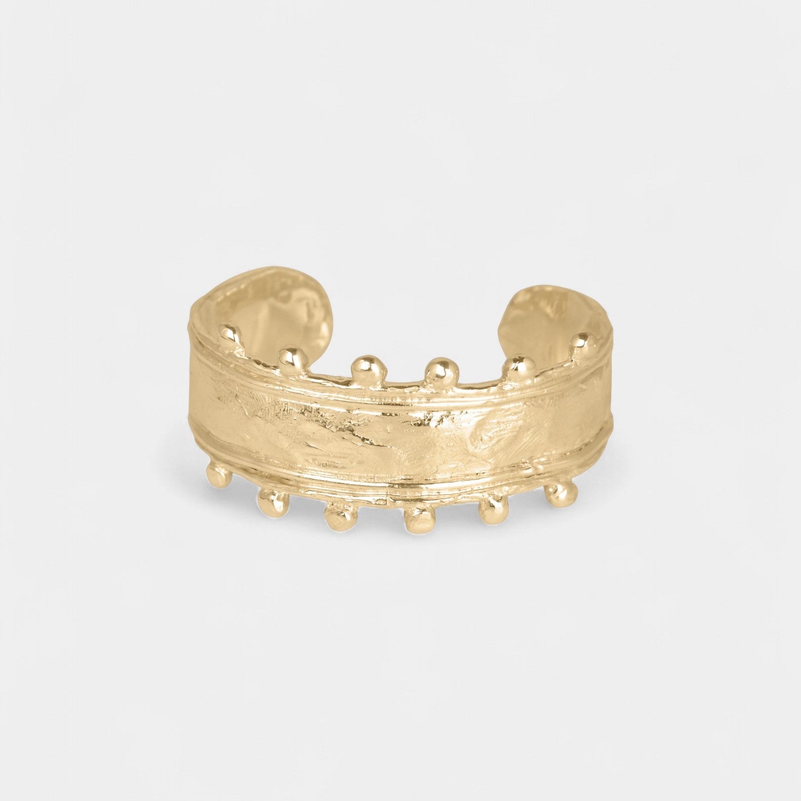 Gold open cuff on a white background