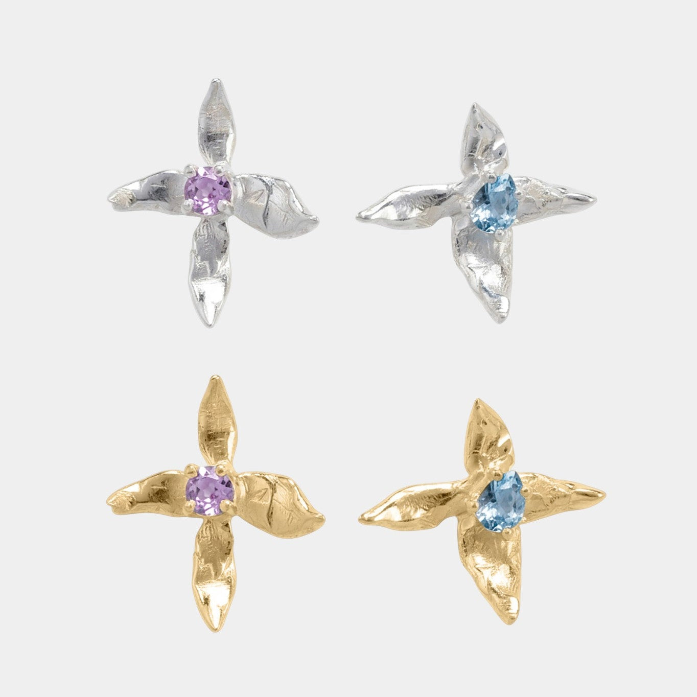 Pair of x-shaped earrings with gemstones on a white background