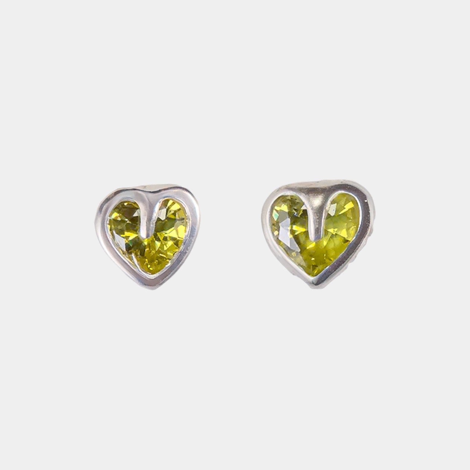 Heart-shaped earrings with green gemstones on a white background