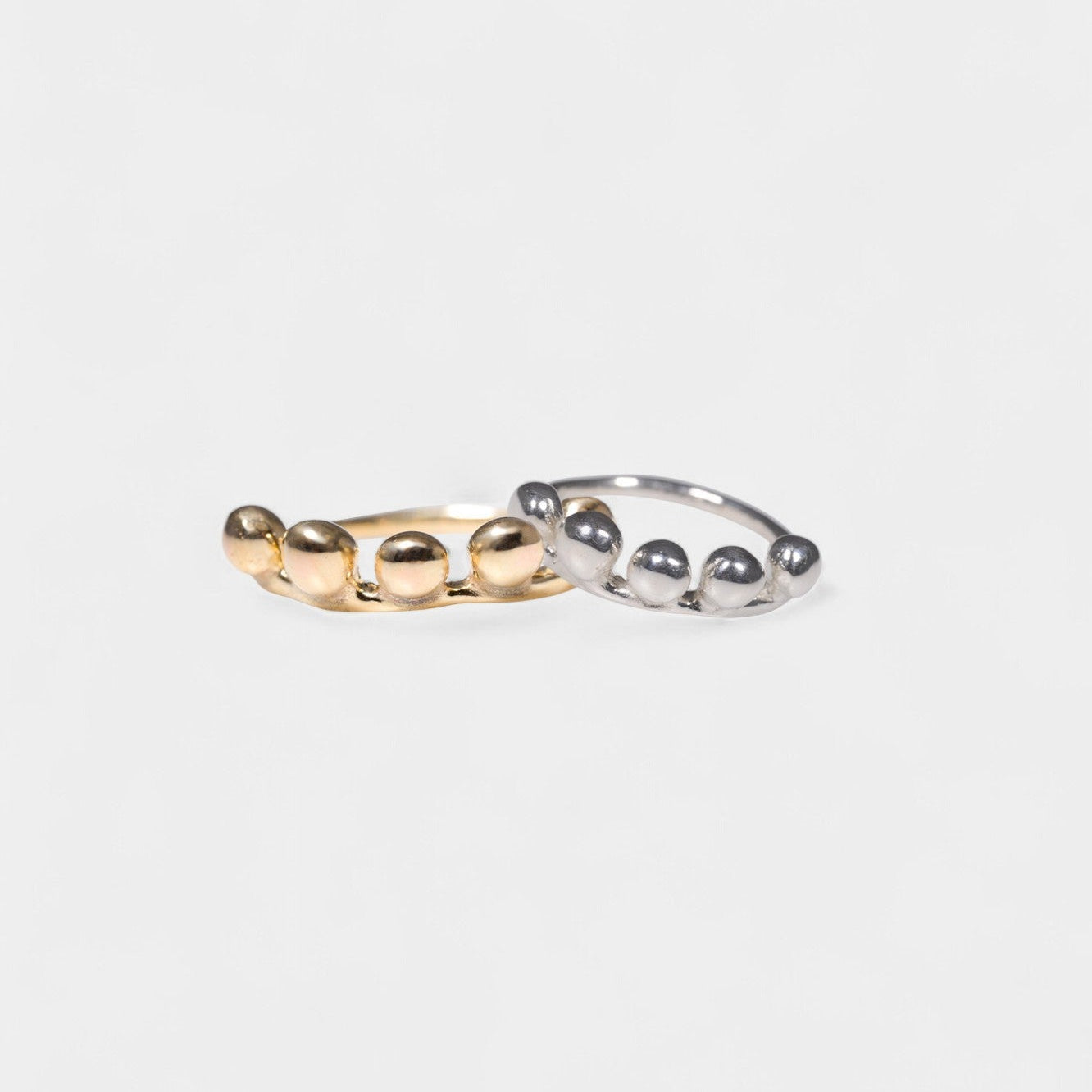 Two cake rings, one with a silver finish, and the other with a gold finish against a white background.