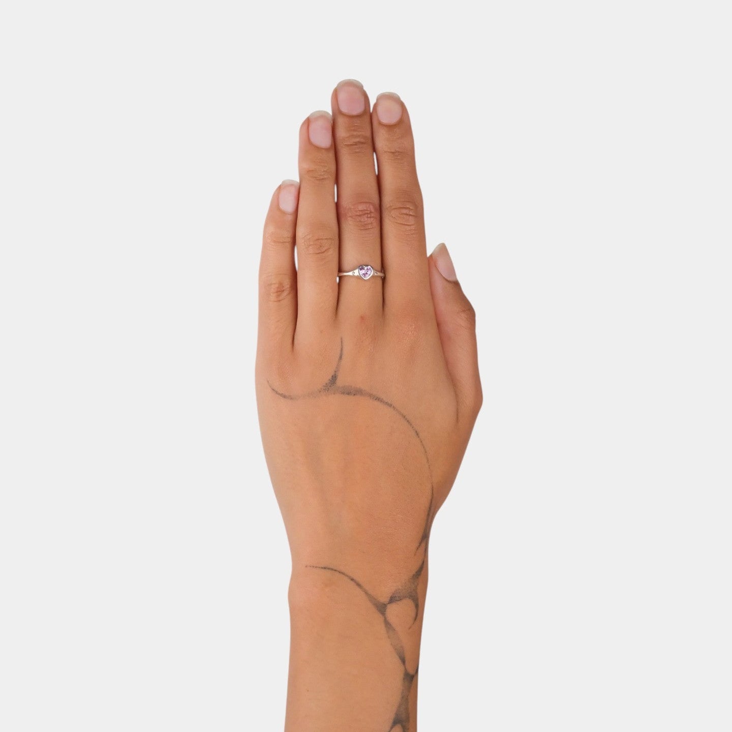 Hand wearing a ring on a plain background