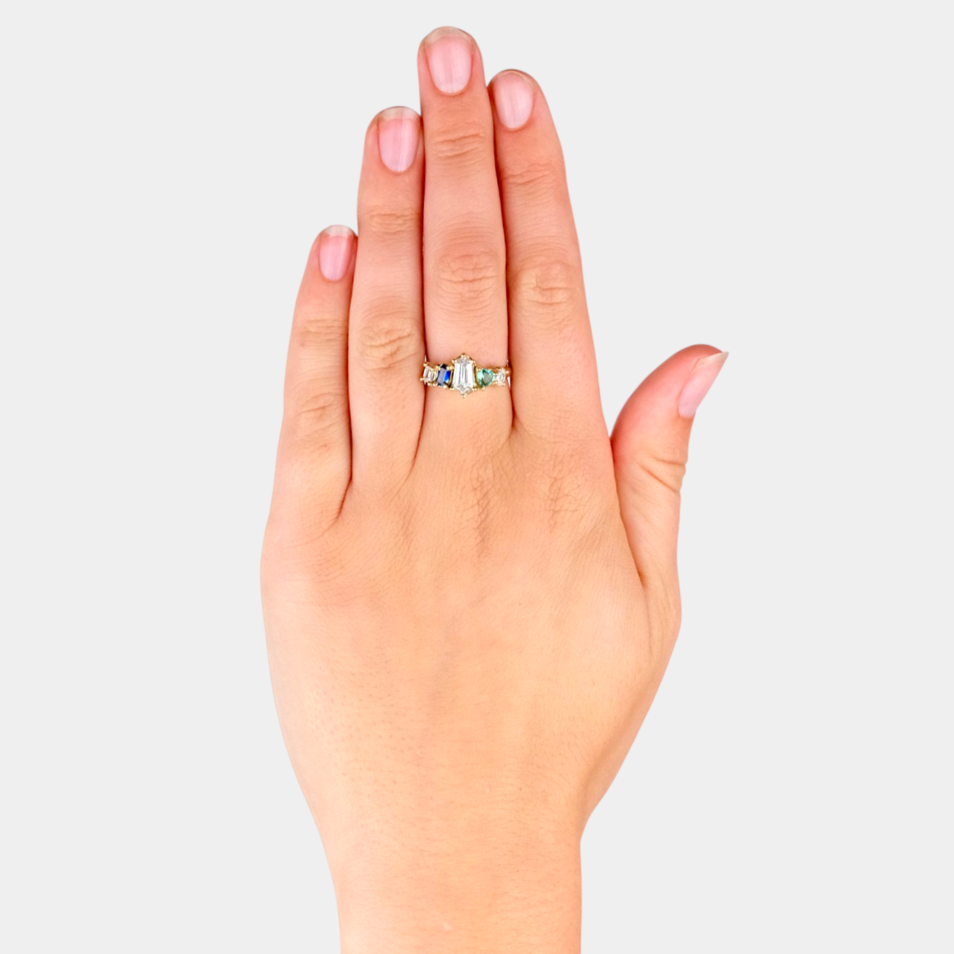 Hand wearing a ring on a light gray background