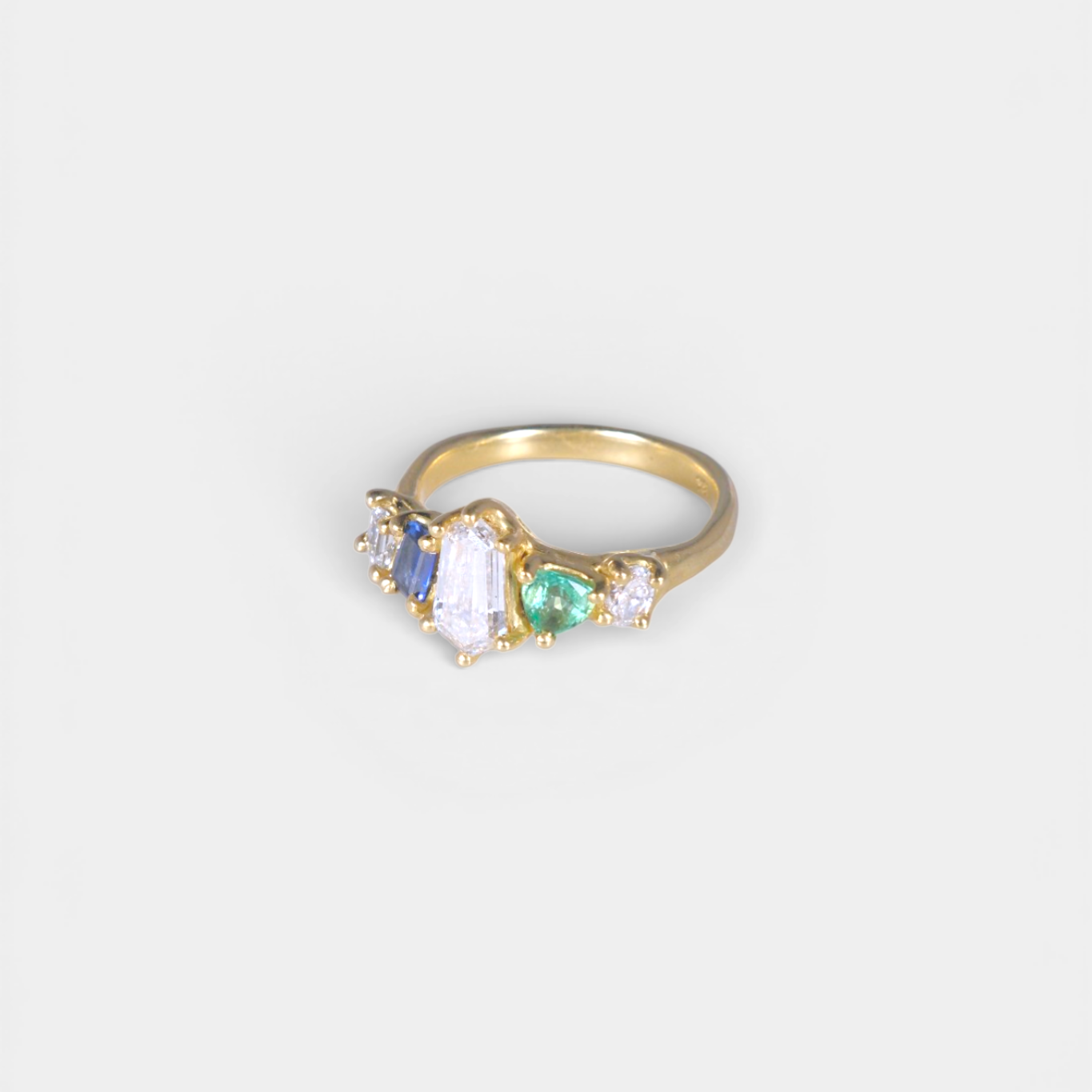 Gold ring with gemstones on a white background