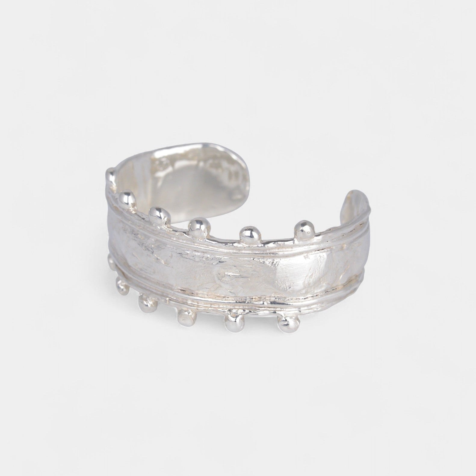 Silver open cuff, side angle, on a white background