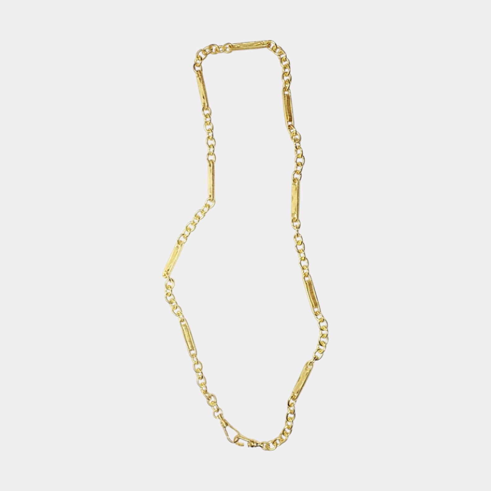 A gold-colored chain necklace displayed against a white background.