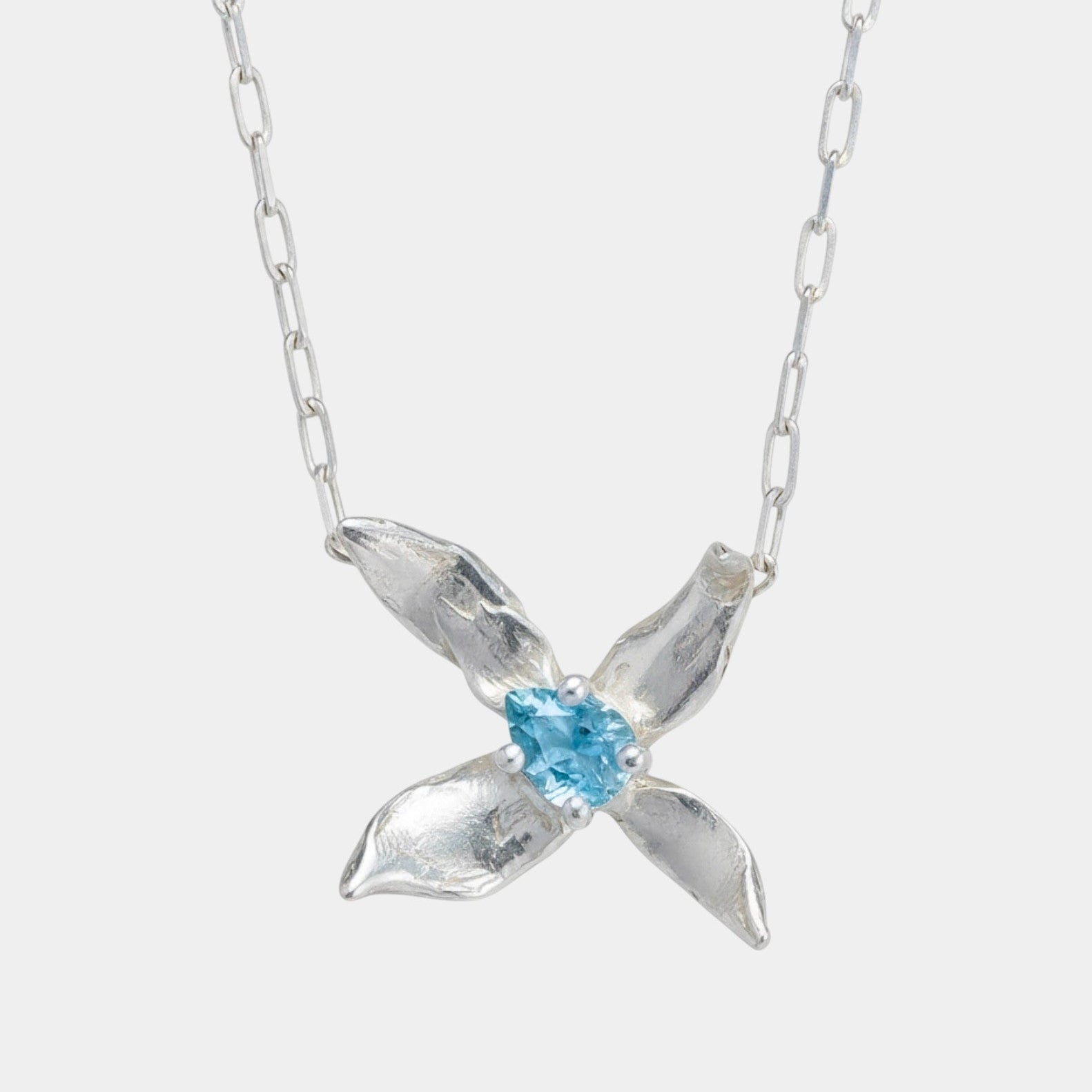 Silver necklace with a blue gemstone pendant on a white background