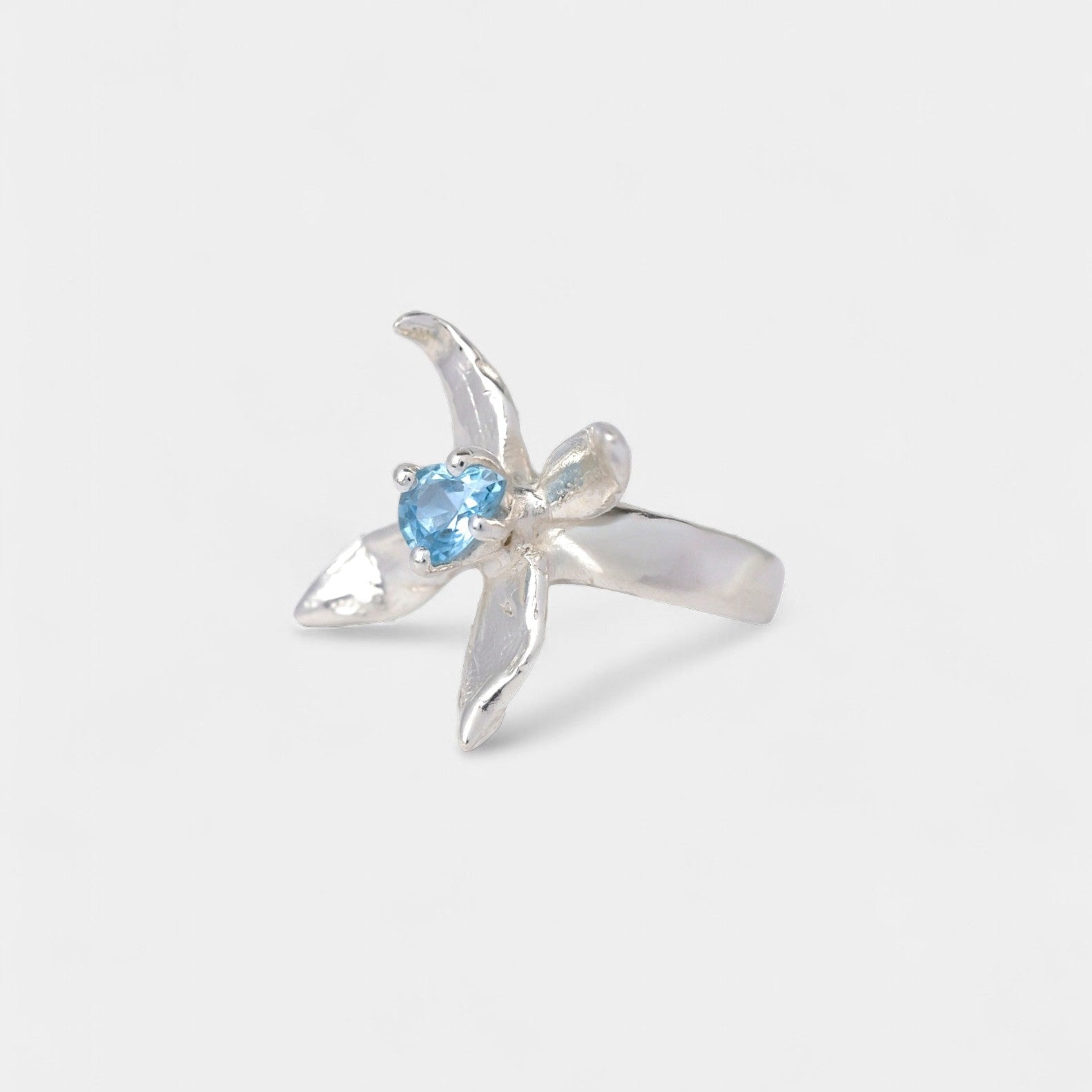 Silver ring with a blue gemstone on a white background