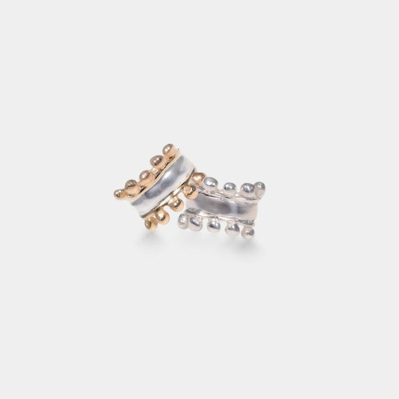 A silver ring with a two-tone design featuring a mix of sterling silver and solid 9 karat yellow gold elements.